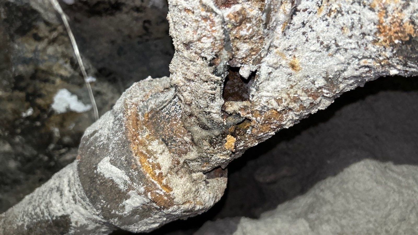 Cast Iron Replacement — Washington Street, Hollywood — before: Horizontal branch drain and laundry branch drain combo fitting connection beneath the foundation — rotted cast iron with holes and missing sections replaced with PVC